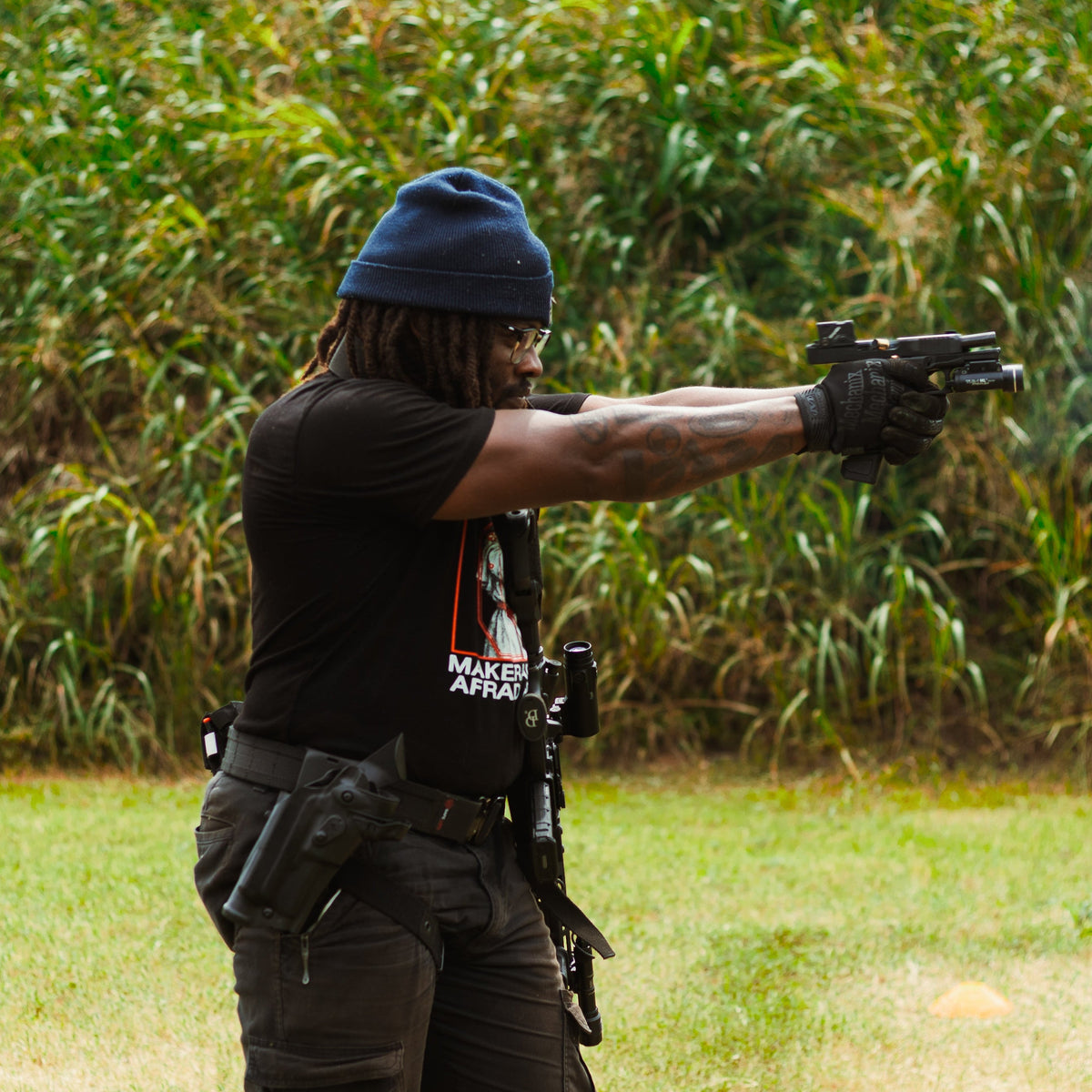 An Arm Your Friends shooter training with a pistol at the outdoor range